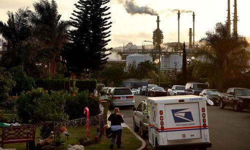 a refinery can be seen from the residential neighborhood abutting it